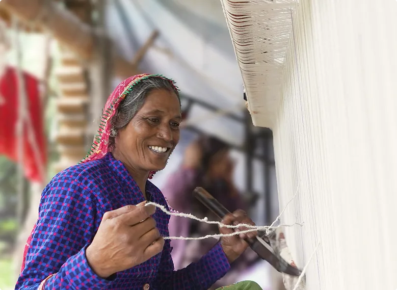 A woman weaving at a loom